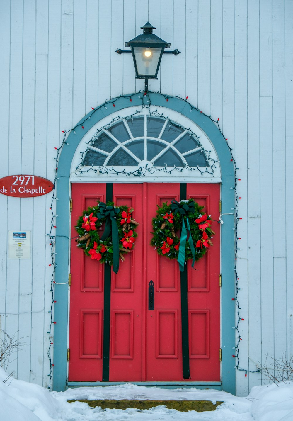 a red door with two wreaths on it