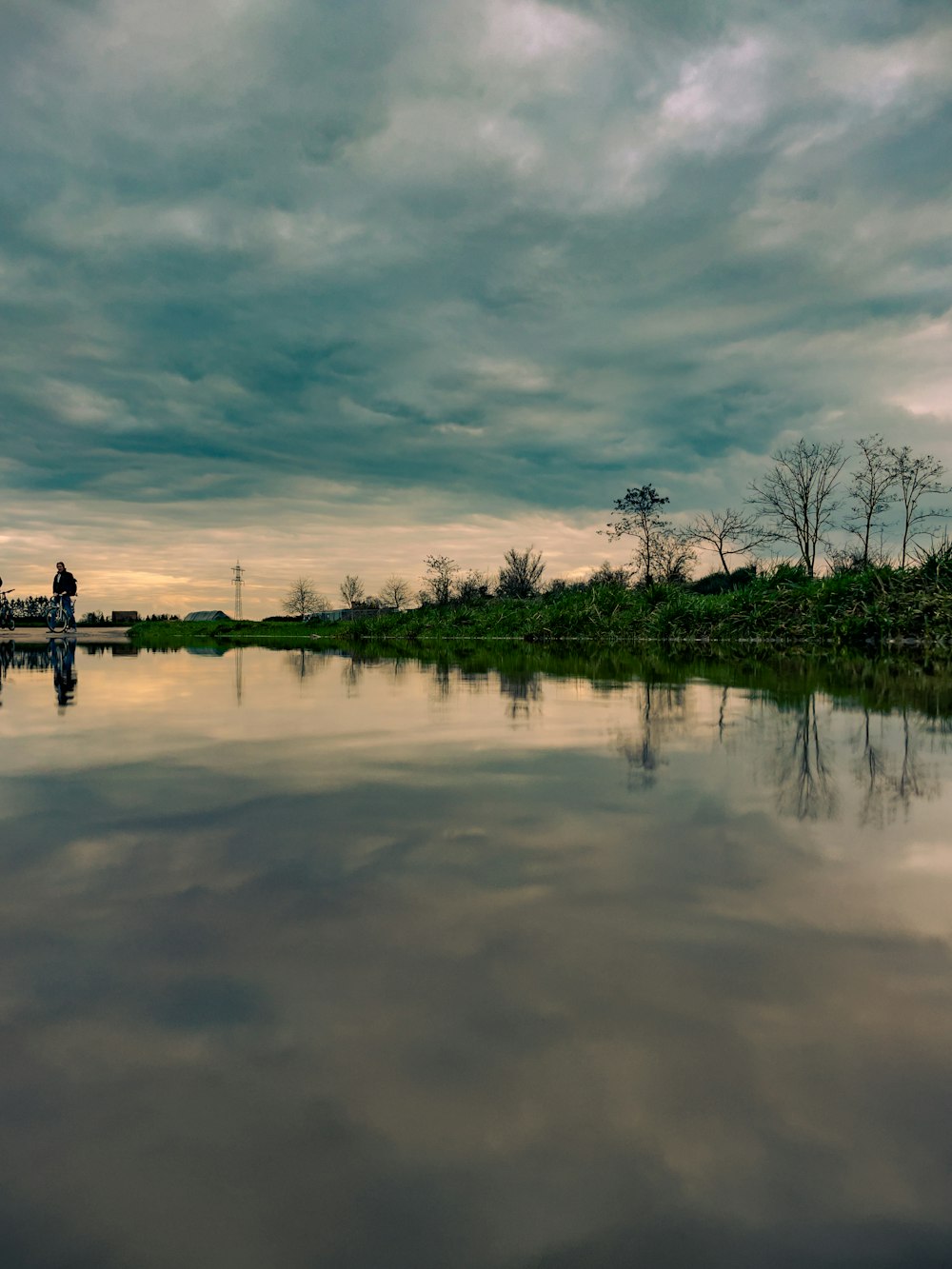 a body of water with a sky filled with clouds