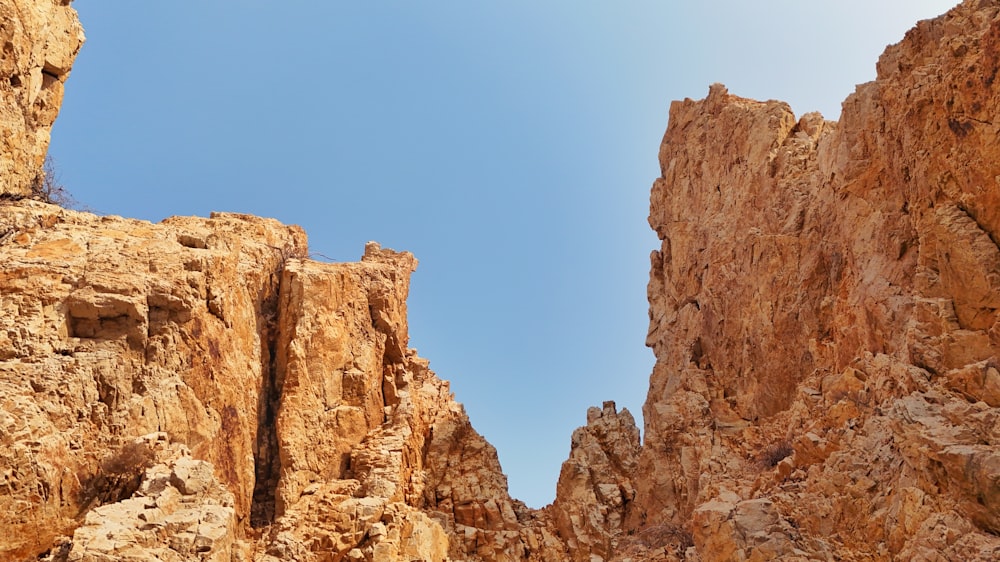 a view of a rocky mountain with a blue sky in the background