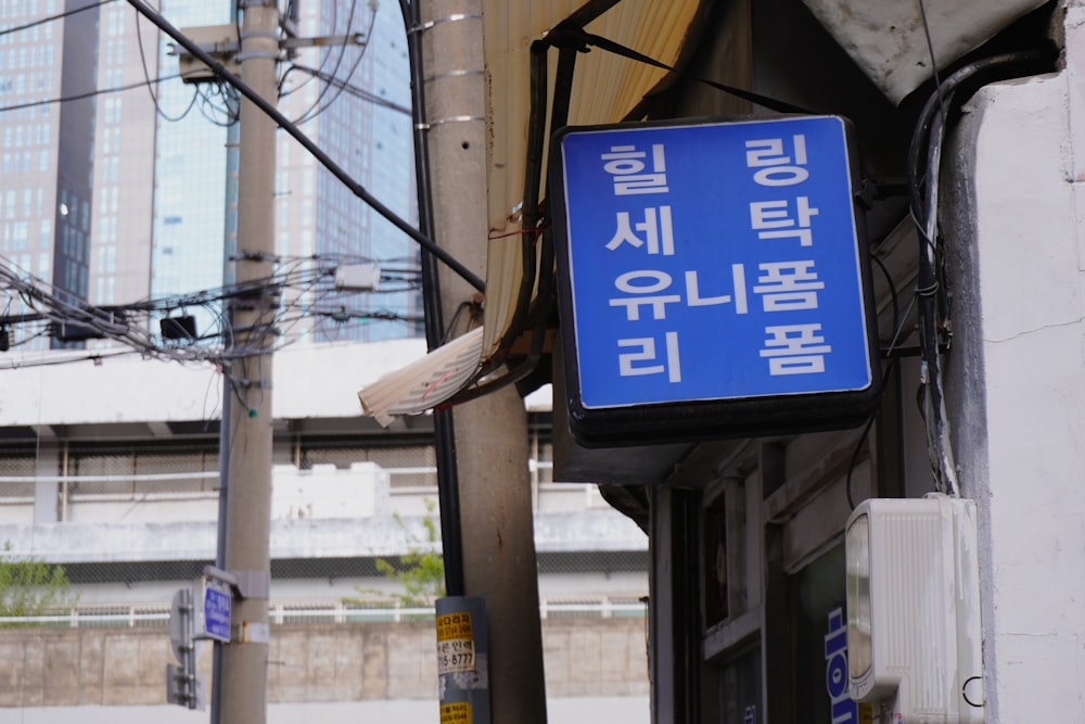 a blue sign hanging from the side of a building