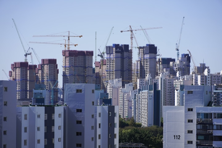 a city with tall buildings and cranes in the background
