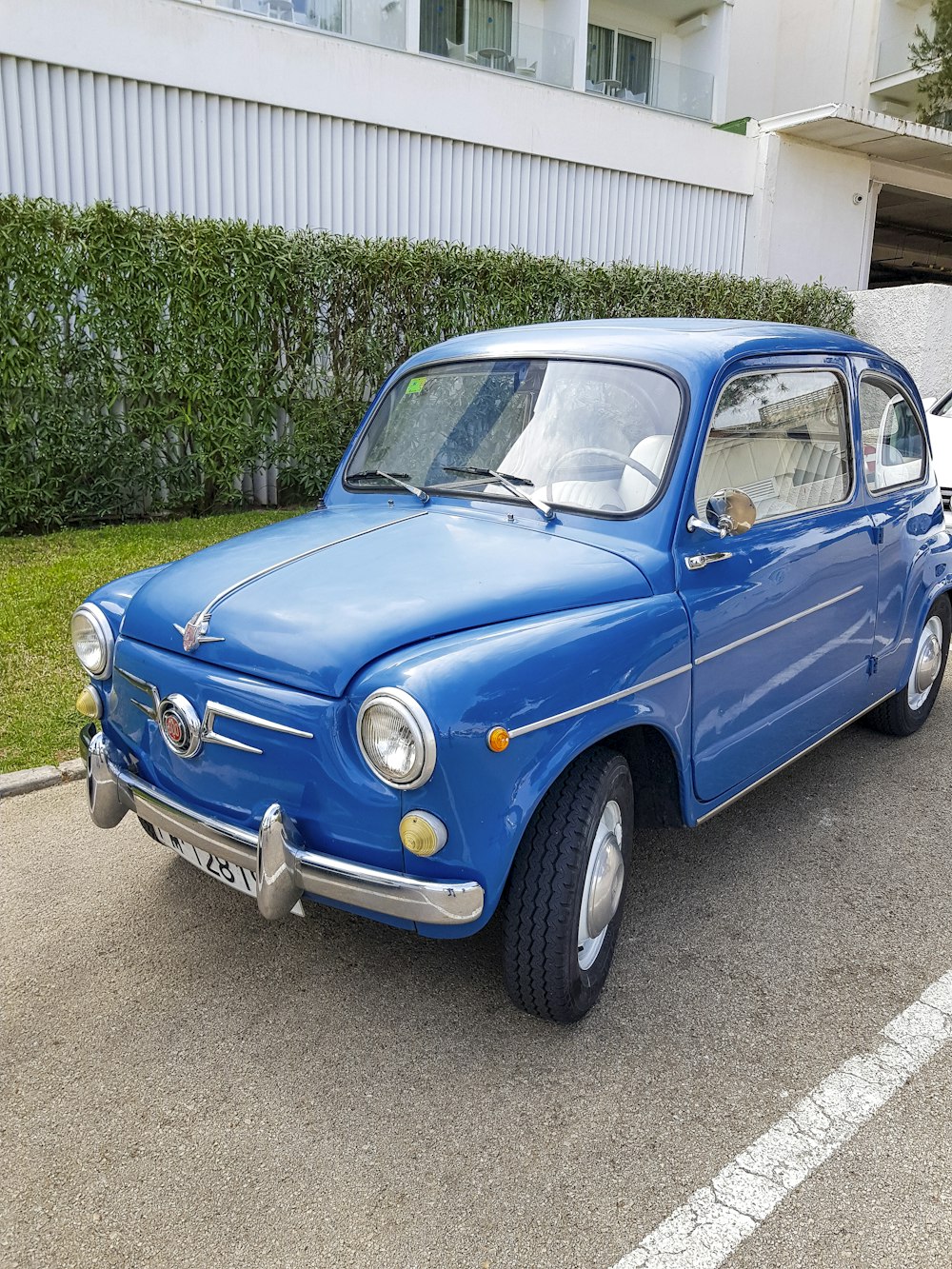 un'auto blu parcheggiata in un parcheggio vicino a un edificio