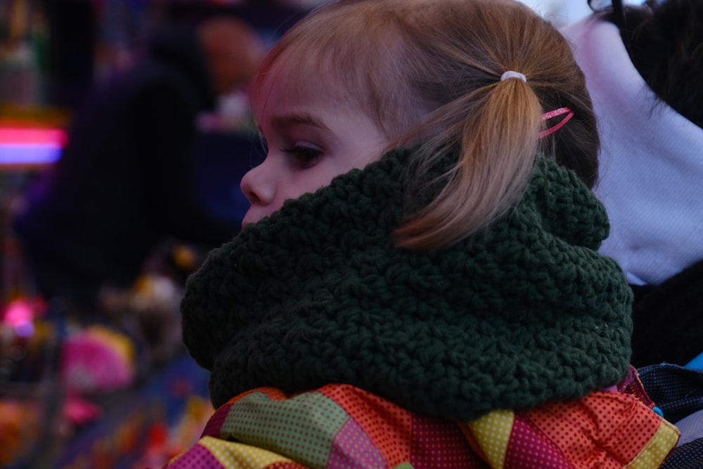 une petite fille portant un foulard autour du cou