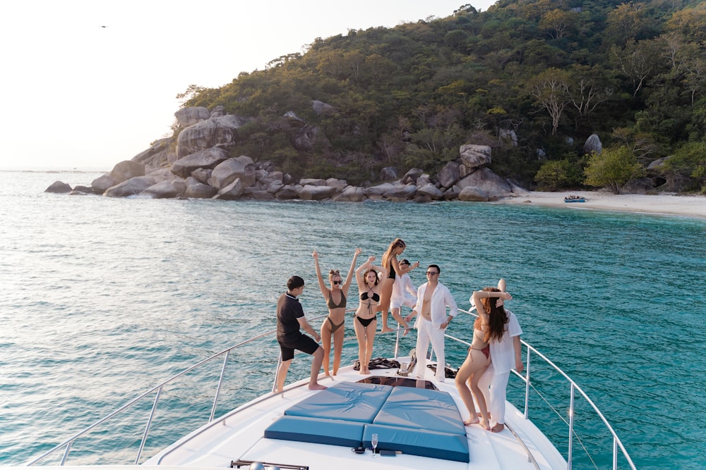 a group of people standing on the back of a boat