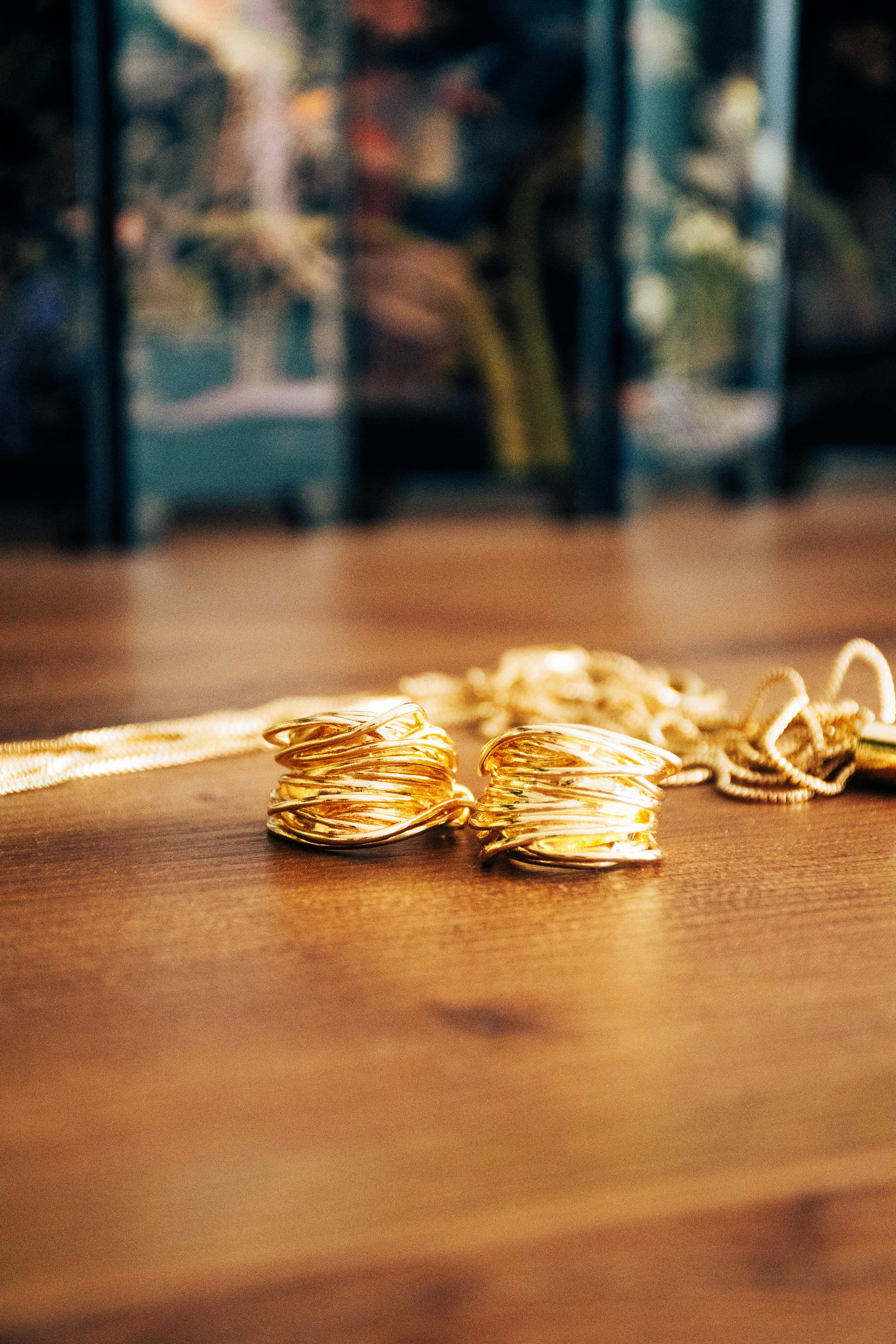 a bunch of gold rings sitting on top of a wooden table