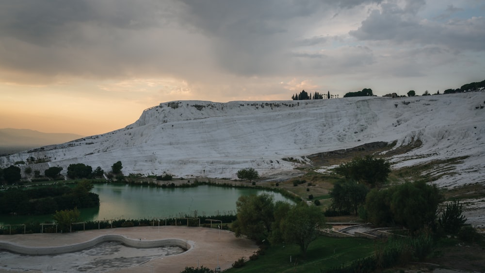 a large body of water sitting next to a white mountain