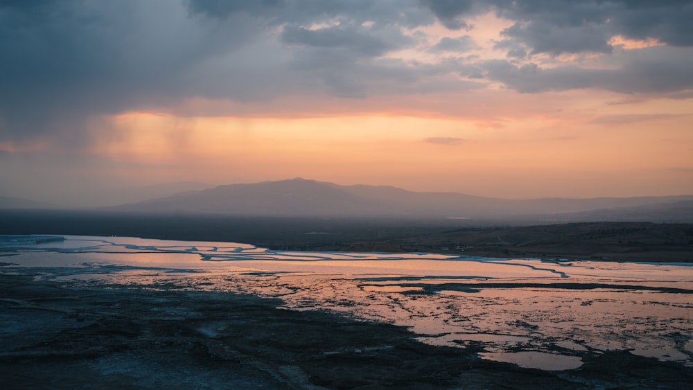 the sun is setting over a body of water