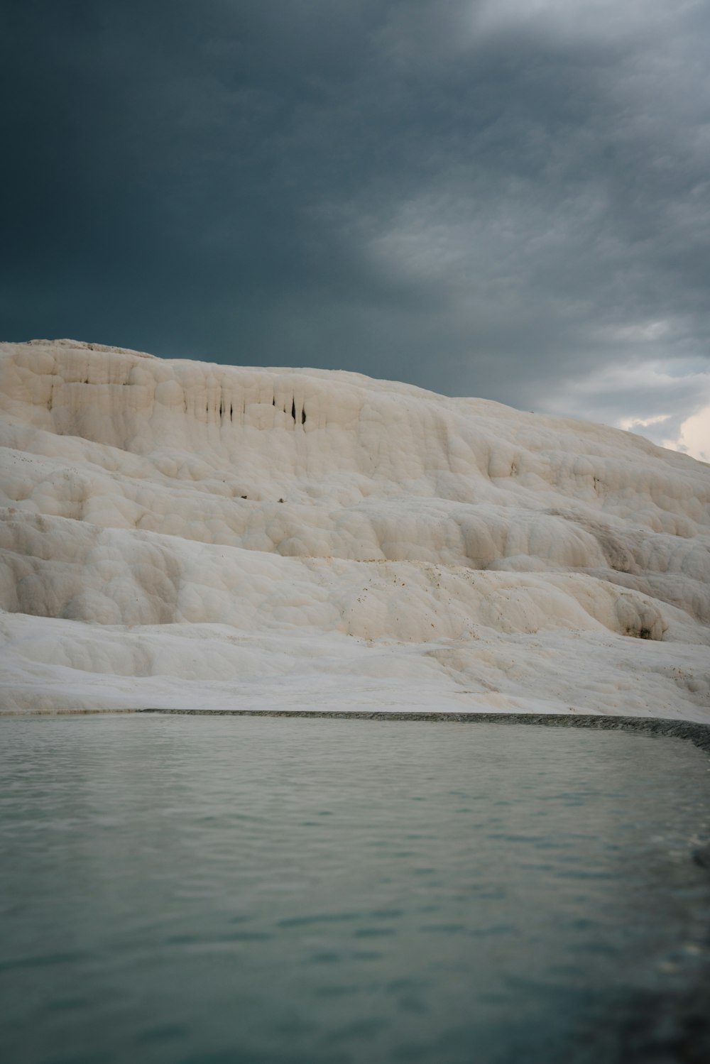 a group of people standing on the edge of a body of water