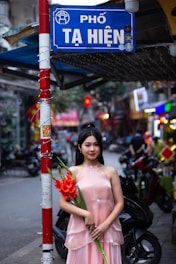 a woman in a pink dress holding a bouquet of flowers
