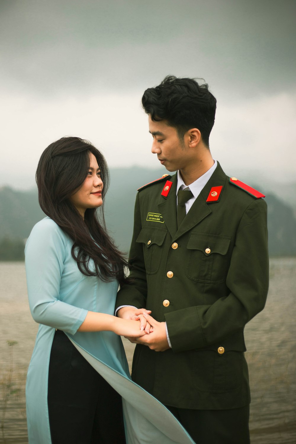 a man in a military uniform and a woman in a blue dress