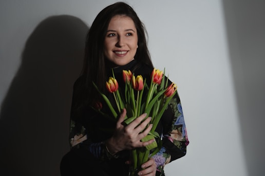 a woman holding a bouquet of flowers in her hands