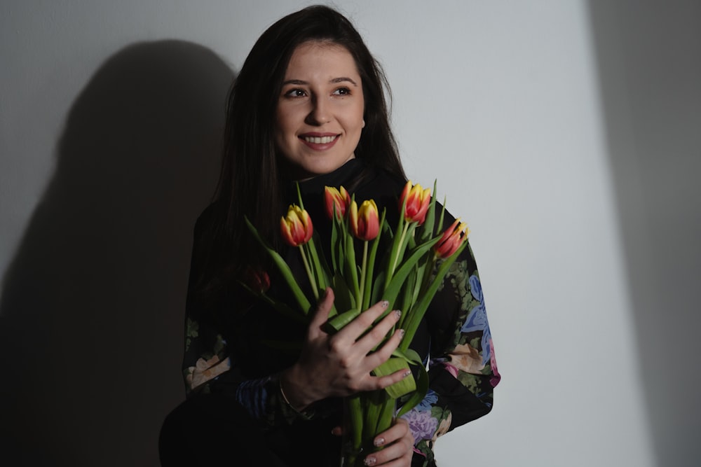 a woman holding a bouquet of flowers in her hands