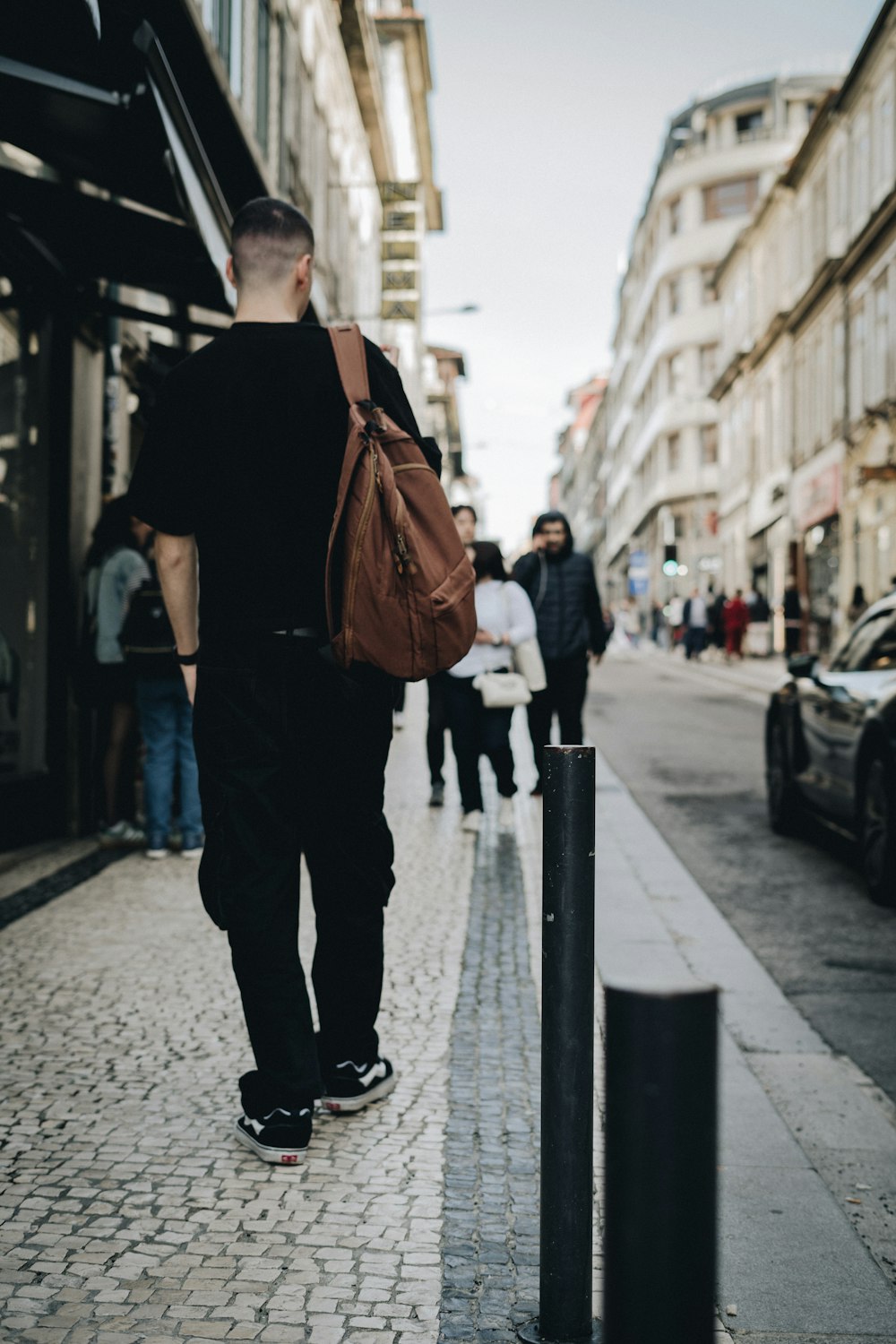 a man walking down a street with a brown bag