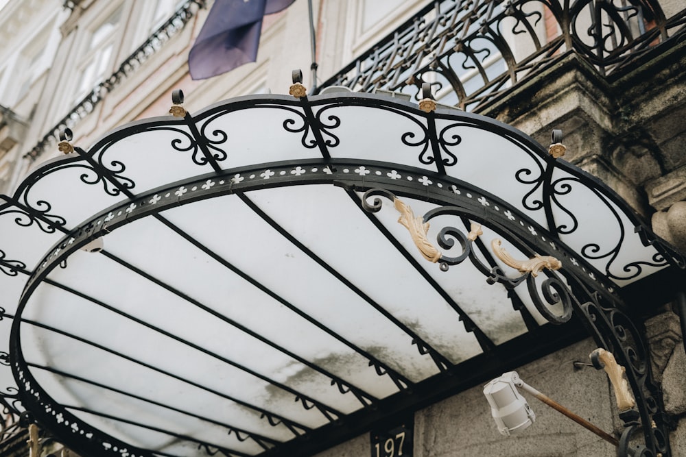 a wrought iron gate on a building with a flag flying in the background