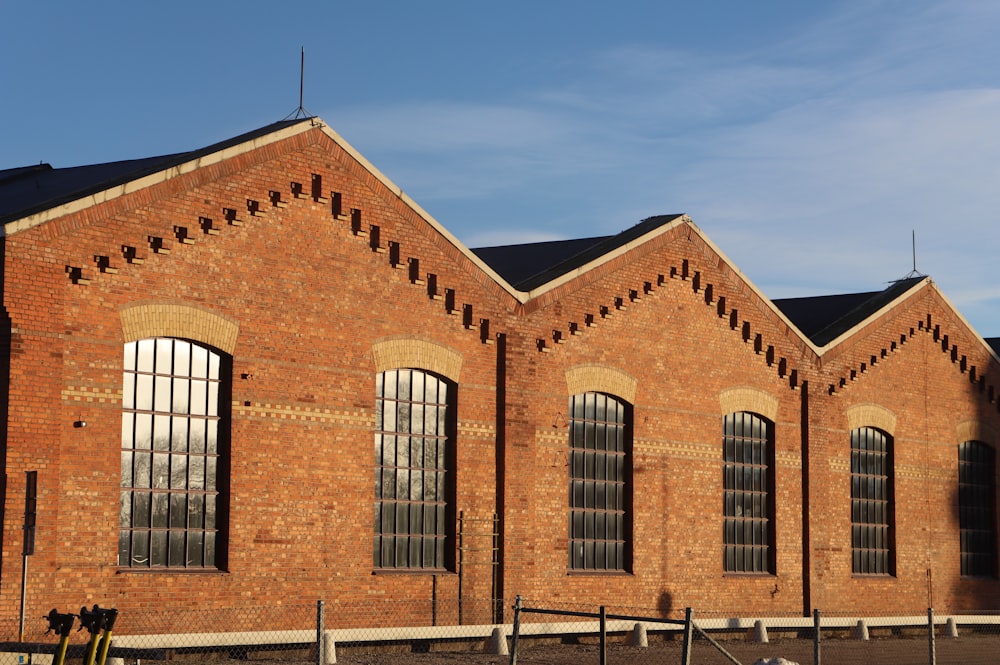 a red brick building with three windows and a black roof