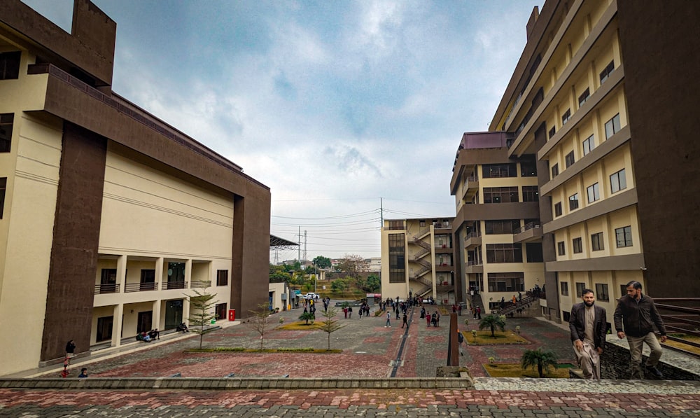 a group of people walking down a street next to tall buildings