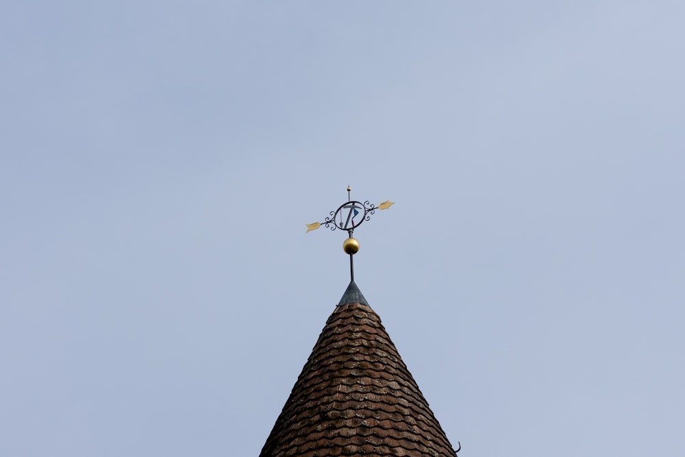 a clock tower with a weather vane on top