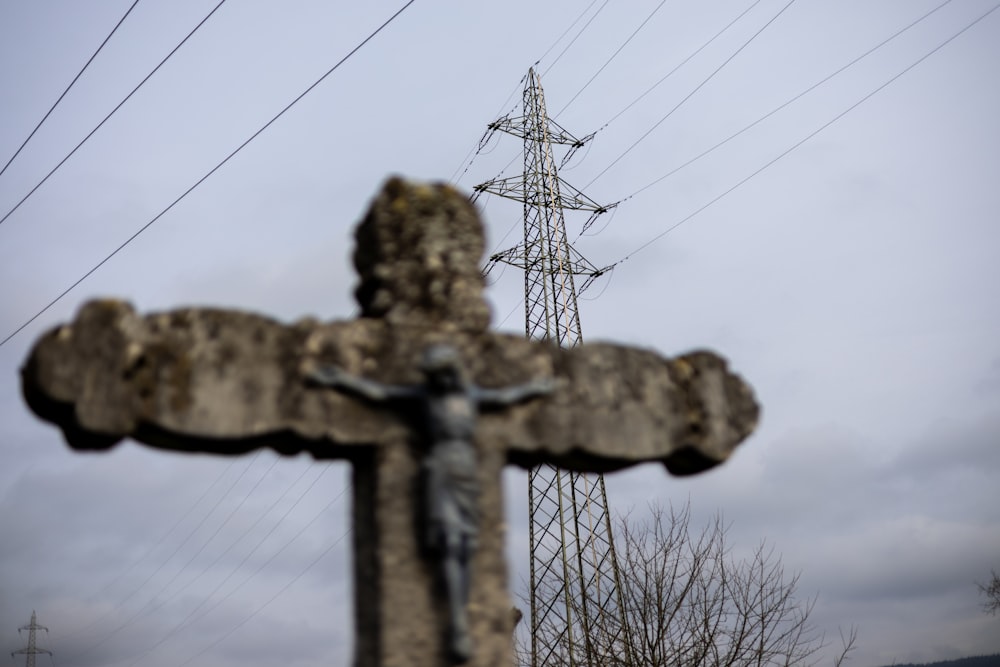 a wooden cross with power lines in the background