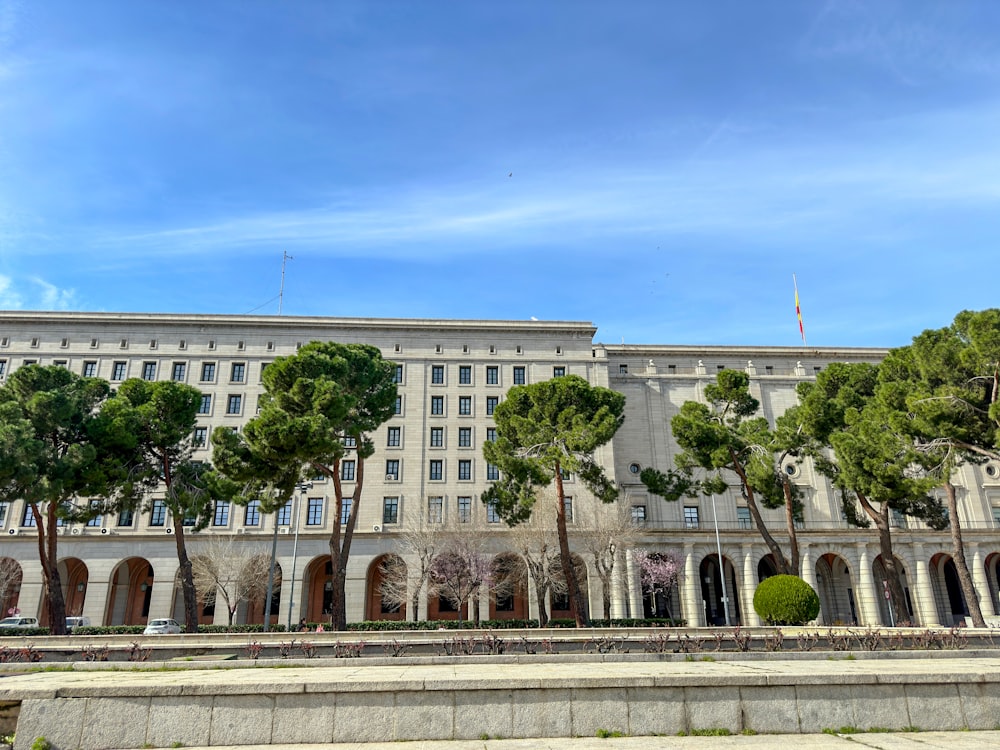 um grande edifício com árvores à sua frente