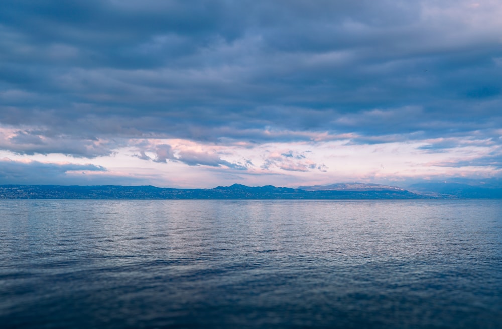 a large body of water under a cloudy sky