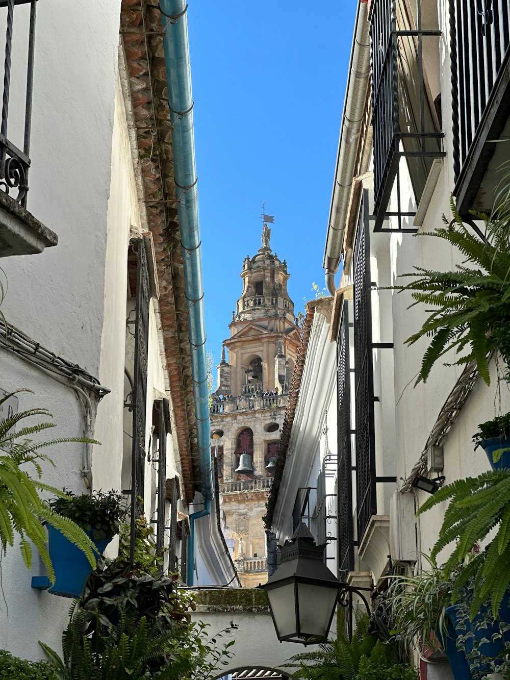 a narrow alley way with a clock tower in the background