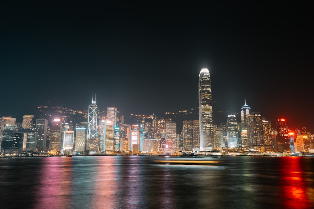 a city skyline at night with lights reflecting off the water