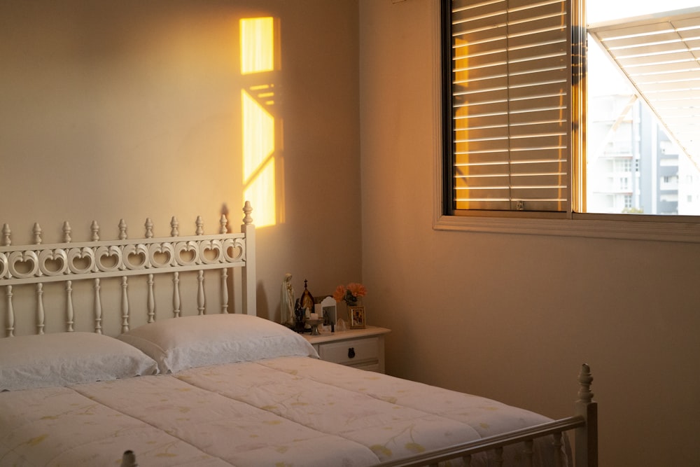 a bedroom with a white bed and a window