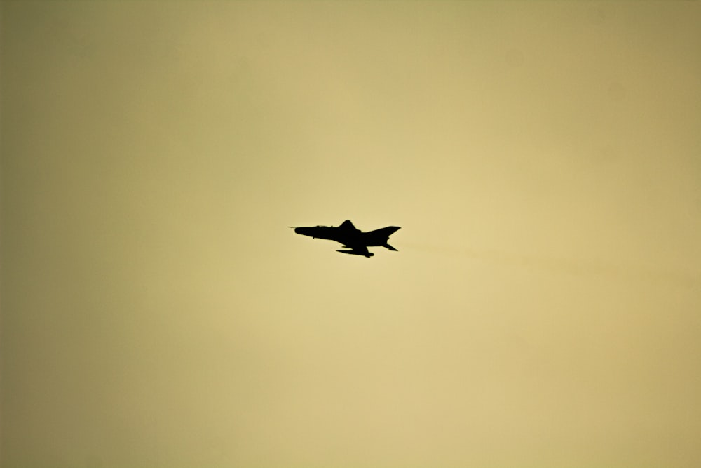 a fighter jet flying through a cloudy sky