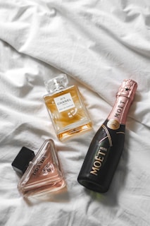 three bottles of perfume sitting on top of a bed