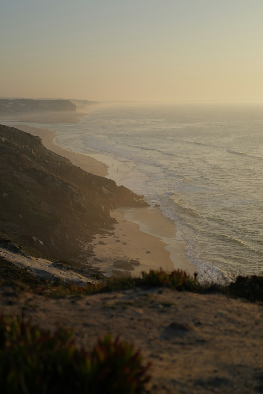 a view of a beach and the ocean from a hill