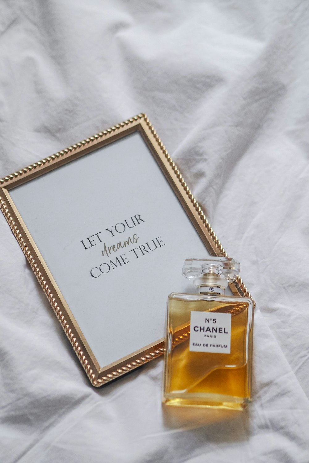 a bottle of perfume sitting next to a picture frame
