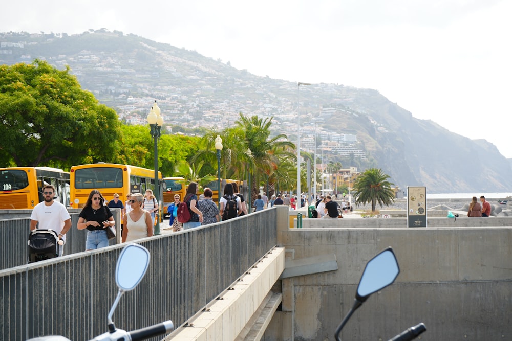 a group of people walking down a street next to a yellow bus