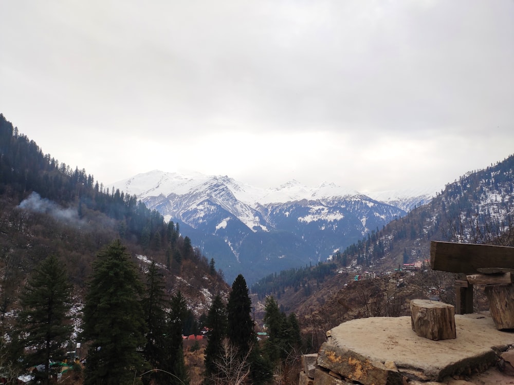 a view of a mountain range with a bench in the foreground