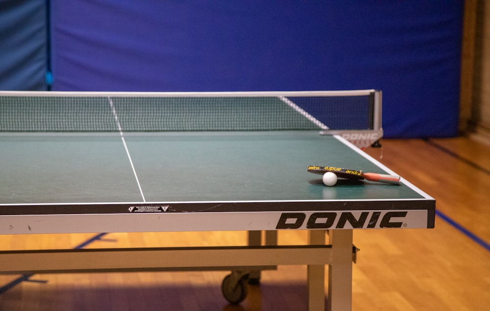 a ping pong table with a racket and ball on it