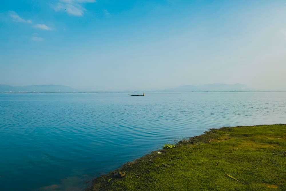 a small boat floating on top of a large body of water