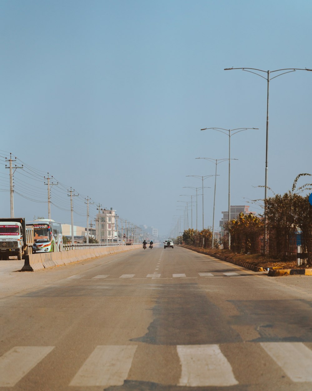 a long empty street with a few vehicles on it