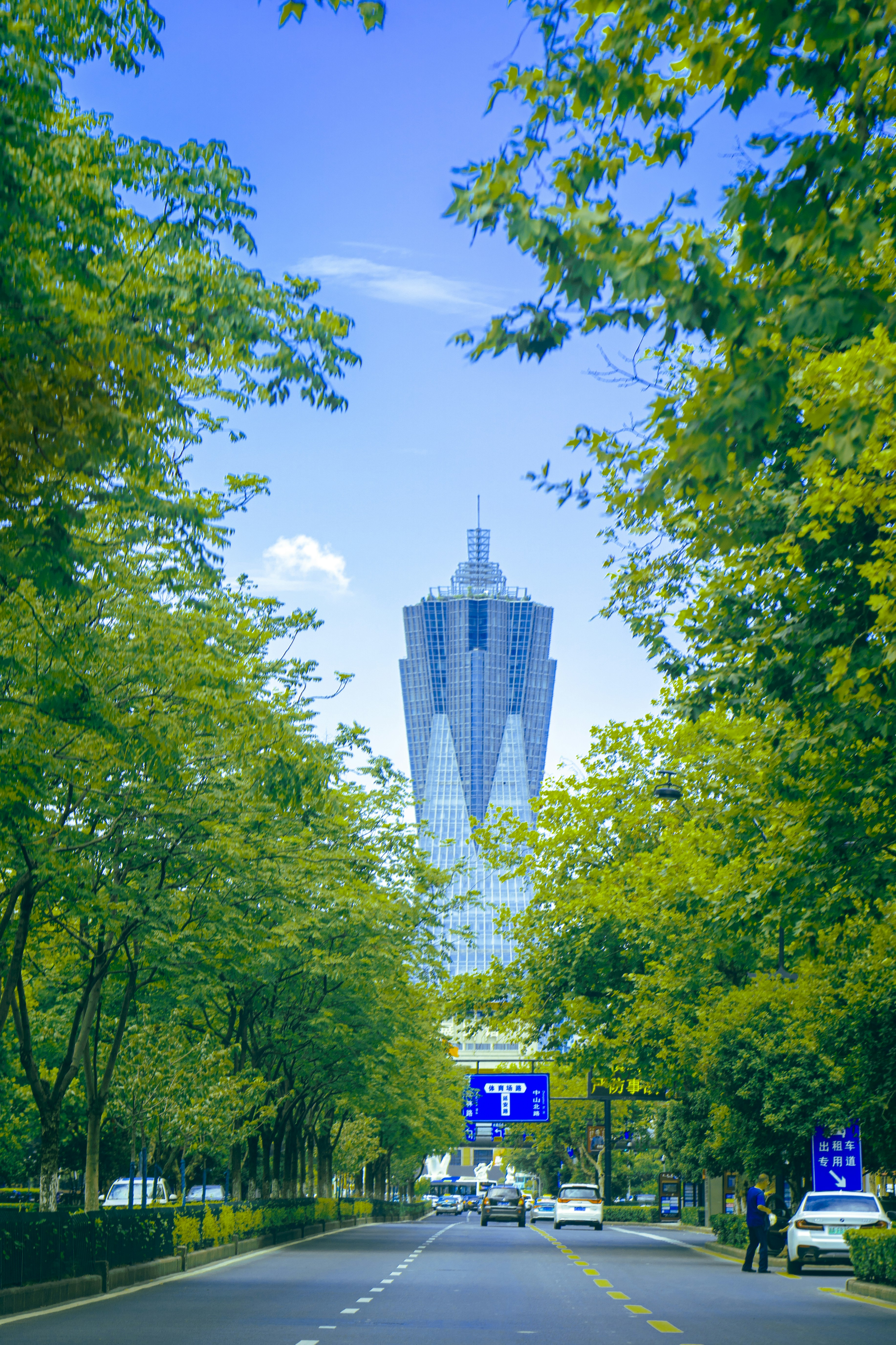 a city street with a tall building in the background