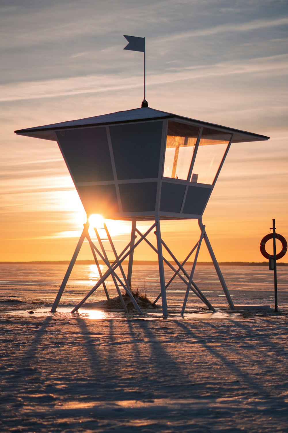 a lifeguard tower sitting on top of a sandy beach