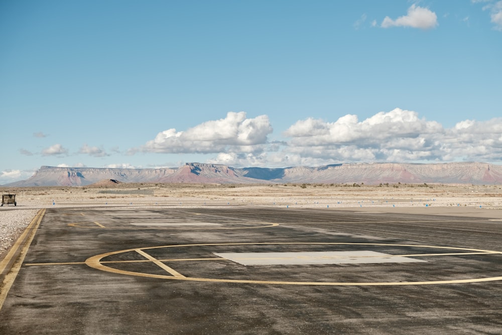 an empty runway with mountains in the background