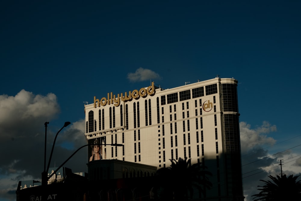 a tall white building with a golden hotel sign on top