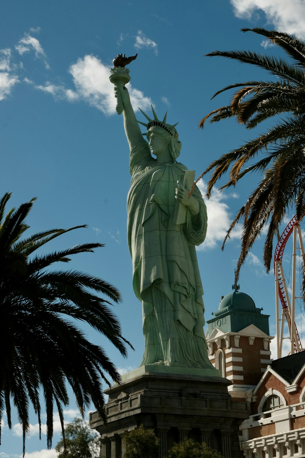 the statue of liberty is surrounded by palm trees