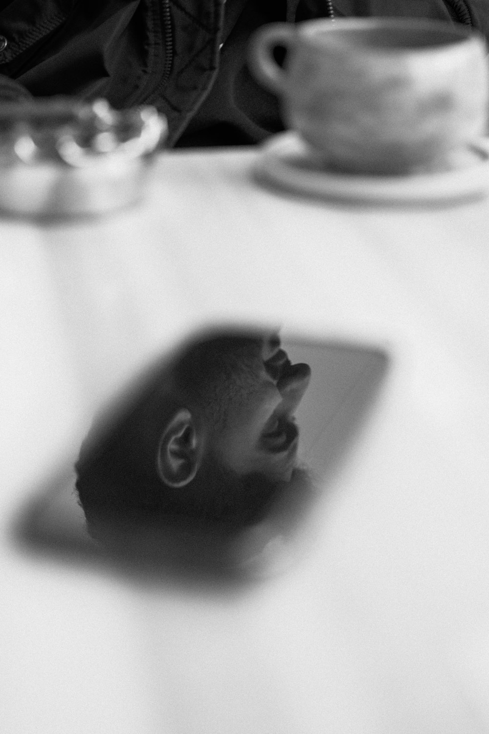 a black and white photo of a man's face on a table
