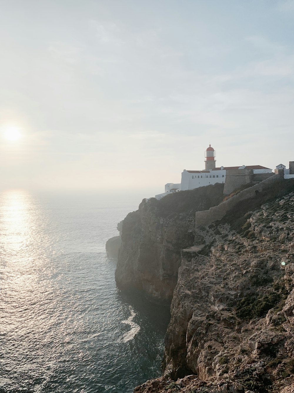 a lighthouse on a cliff overlooking the ocean