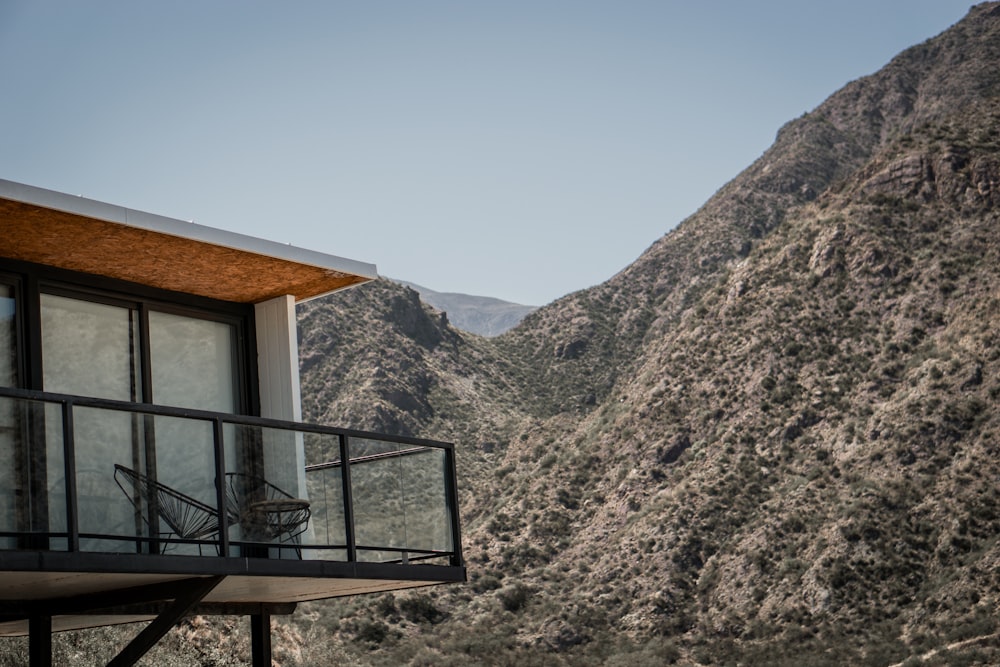 a balcony overlooking a mountain with a chair on it