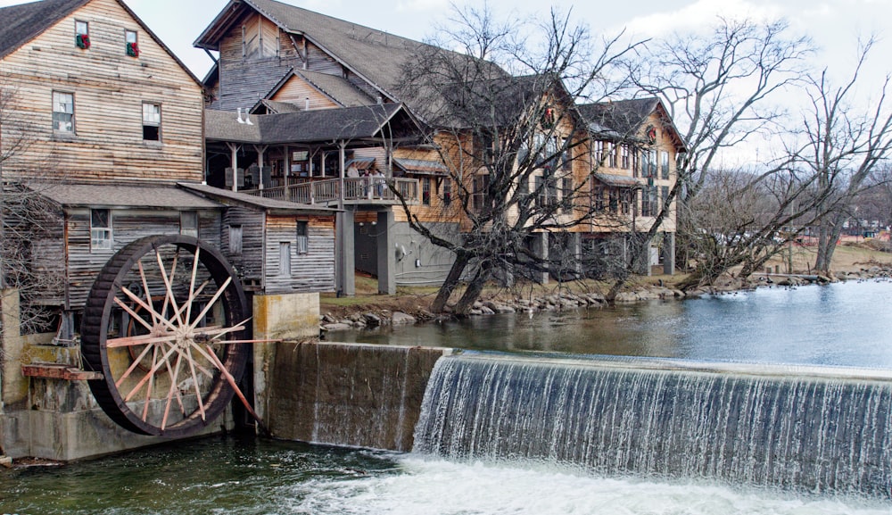 an old mill with a water wheel in front of it