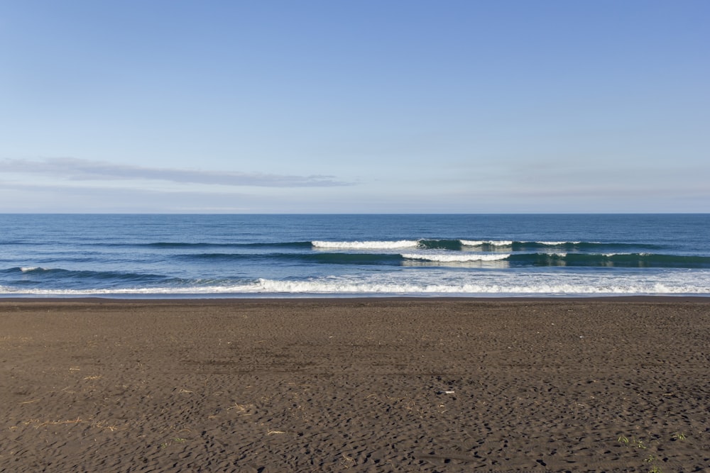 a sandy beach with waves coming in to shore