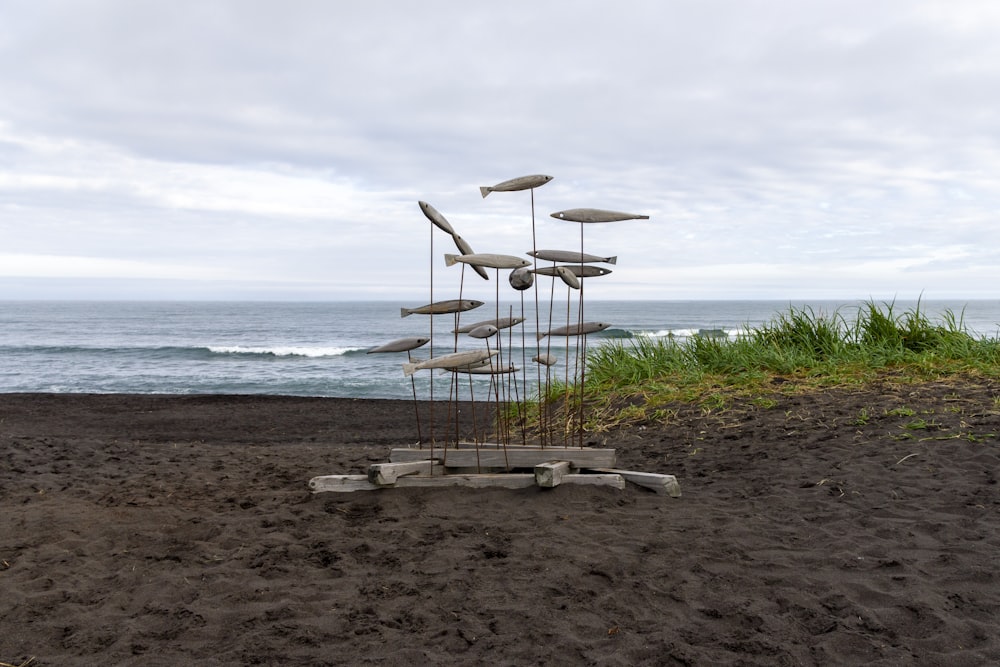 a sculpture on a sandy beach near the ocean