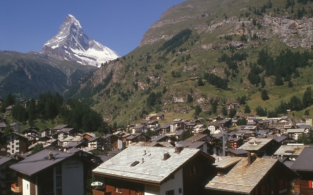 uma vista de uma aldeia com uma montanha ao fundo