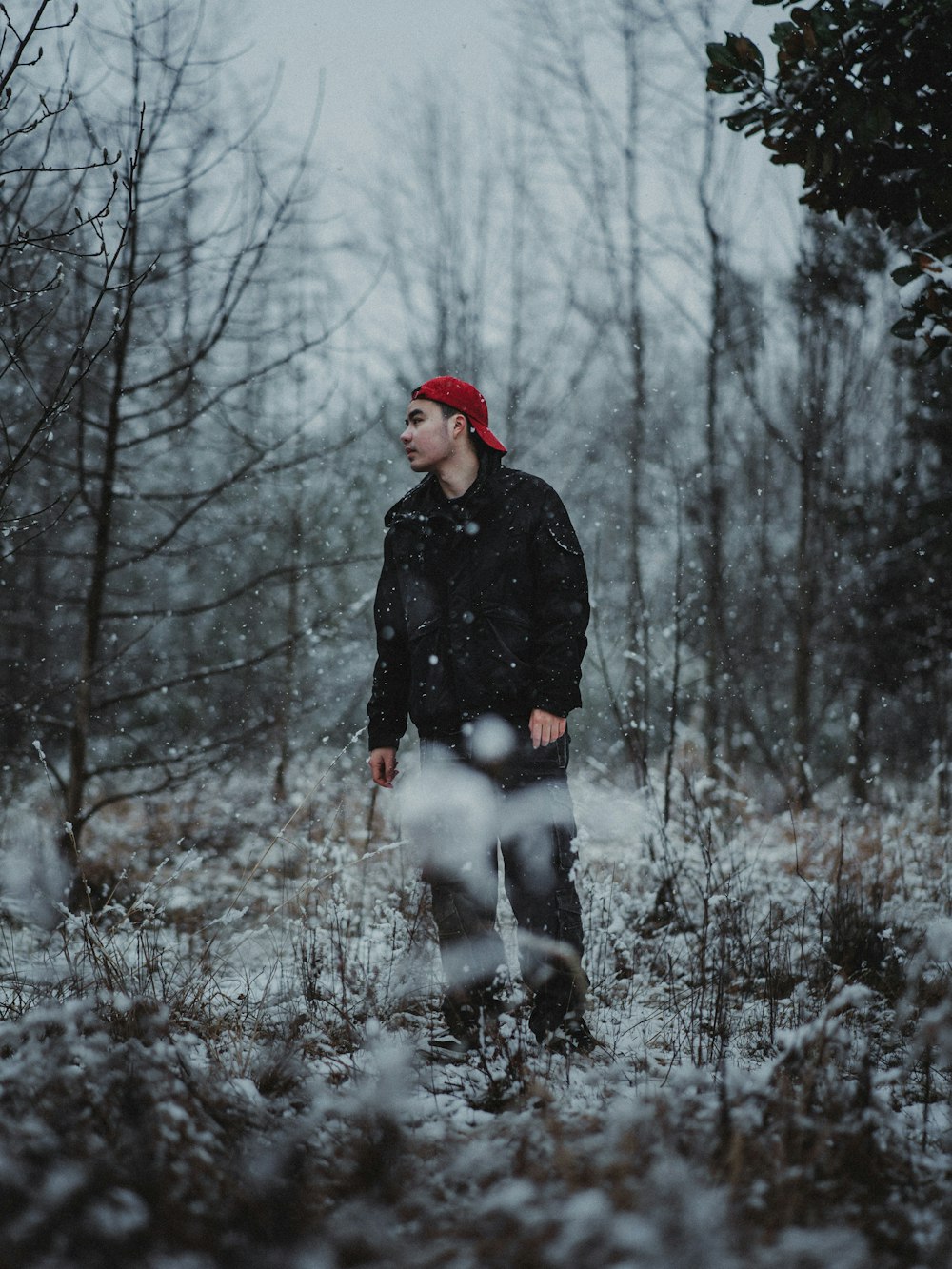 a man standing in the snow in a forest