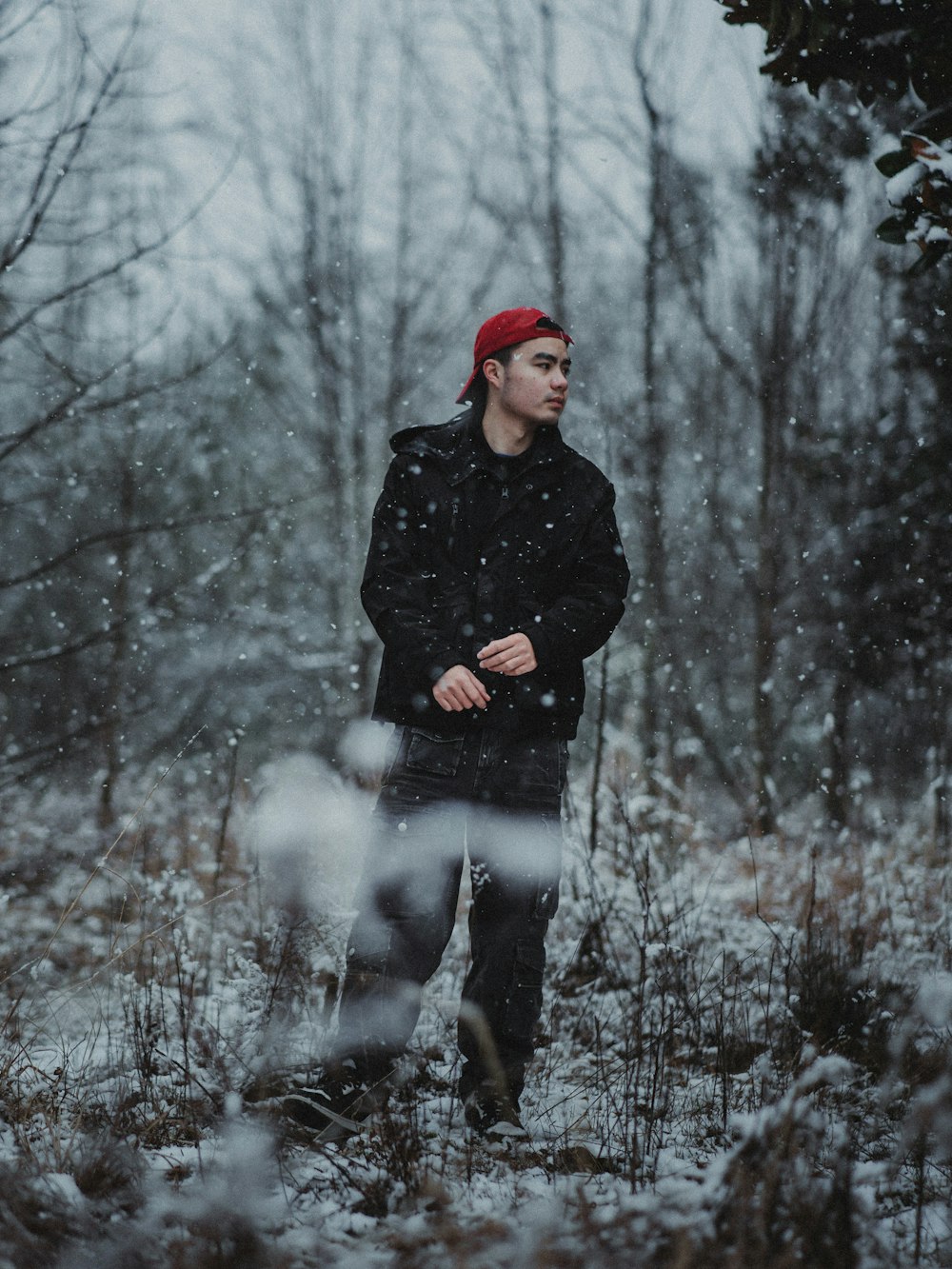 a man standing in the snow in a forest